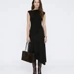 Woman wearing a black dress holding a brown handbag on a white background