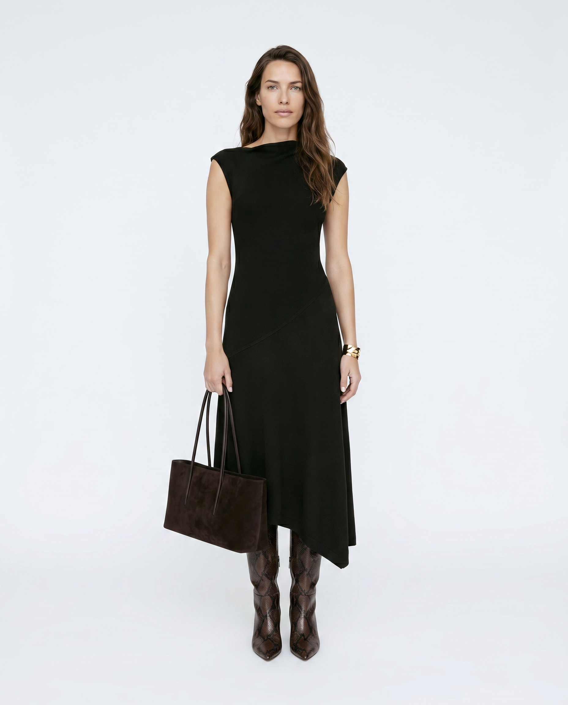 Woman wearing a black dress holding a brown handbag on a white background