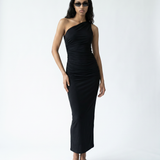 Woman wearing a black one-shoulder dress on a white background