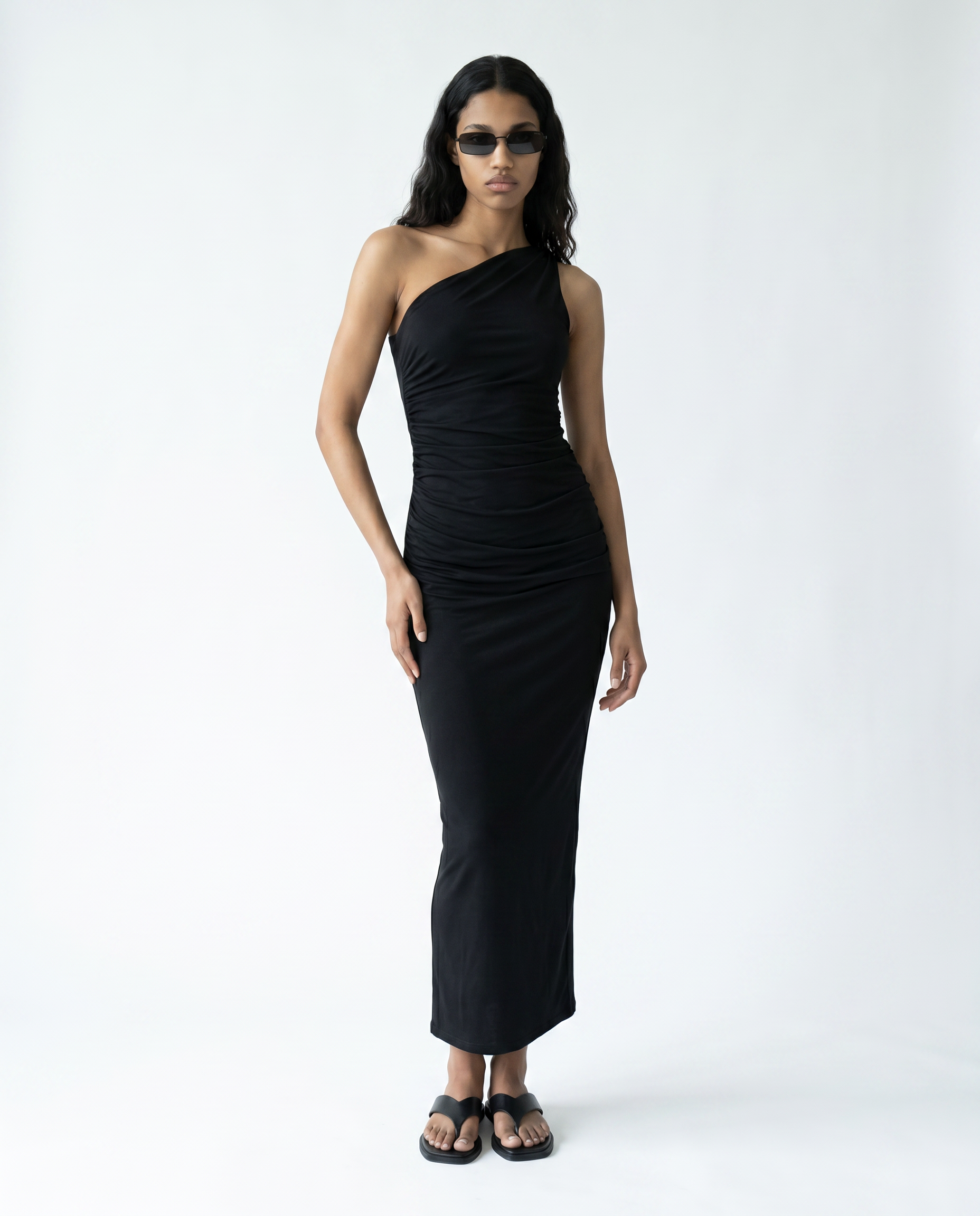 Woman wearing a black one-shoulder dress on a white background