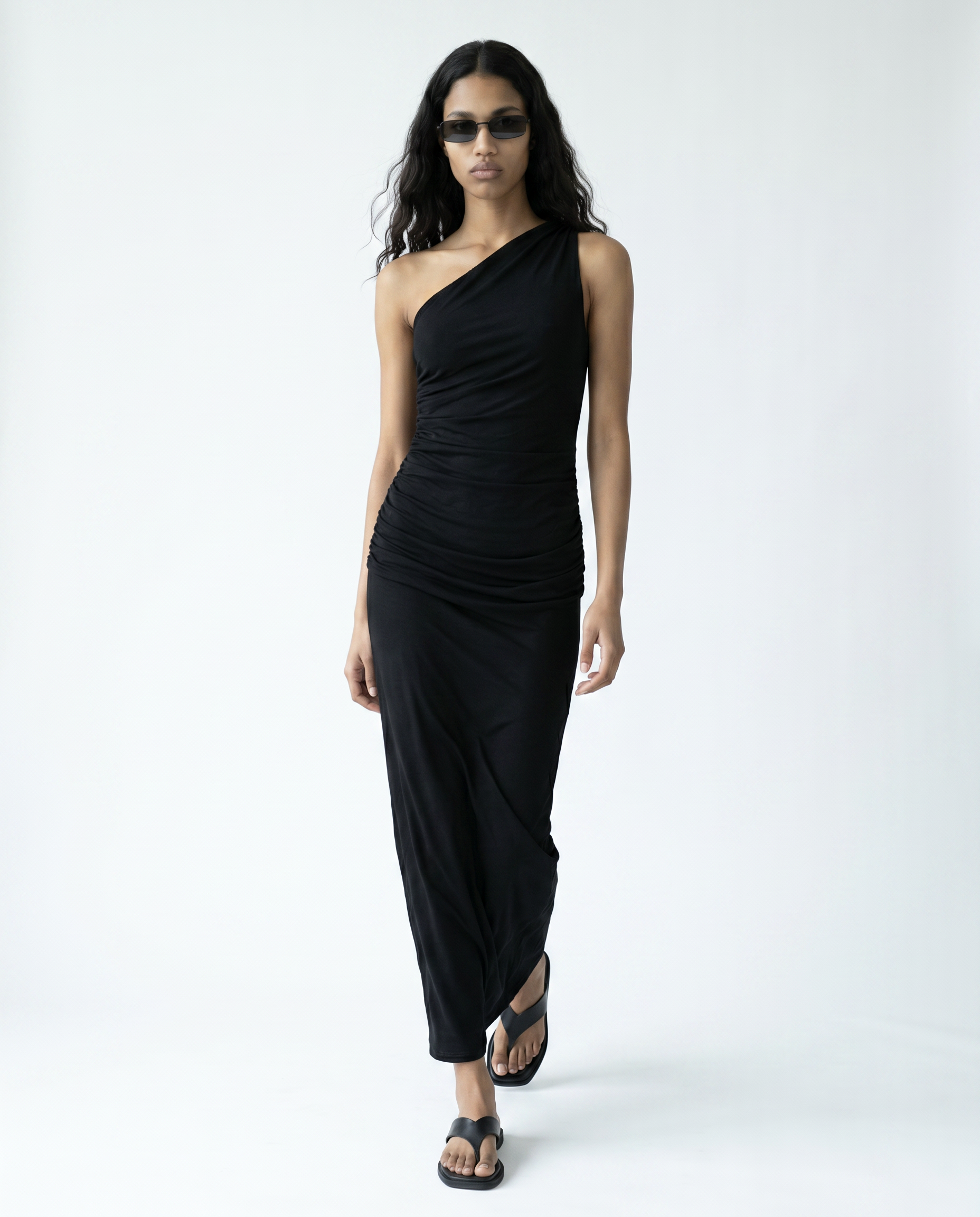 Woman wearing a black one-shoulder dress on a white background