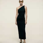 Woman wearing a black one-shoulder dress against a beige background