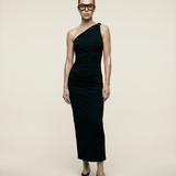 Woman wearing a black one-shoulder dress against a beige background