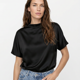 Woman wearing a black t-shirt and blue jeans on a white background