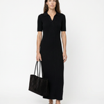 Woman wearing a black dress holding a black bag on a white background