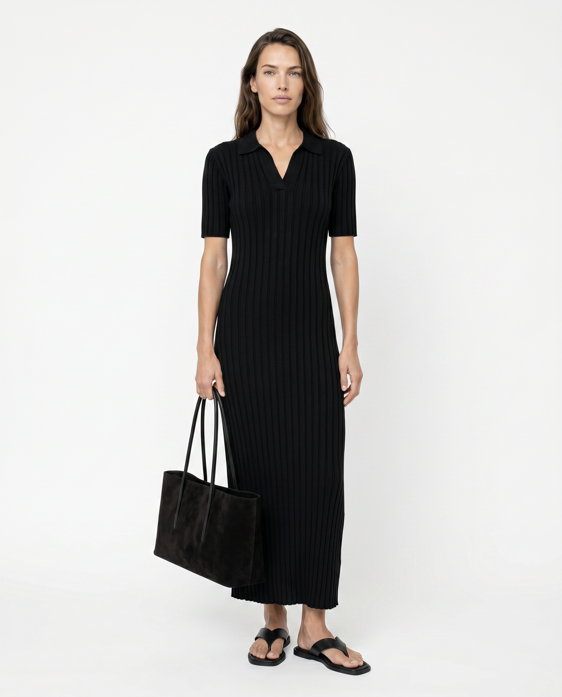 Woman wearing a black dress holding a black bag on a white background