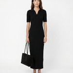 Woman wearing a black dress holding a black bag on a white background