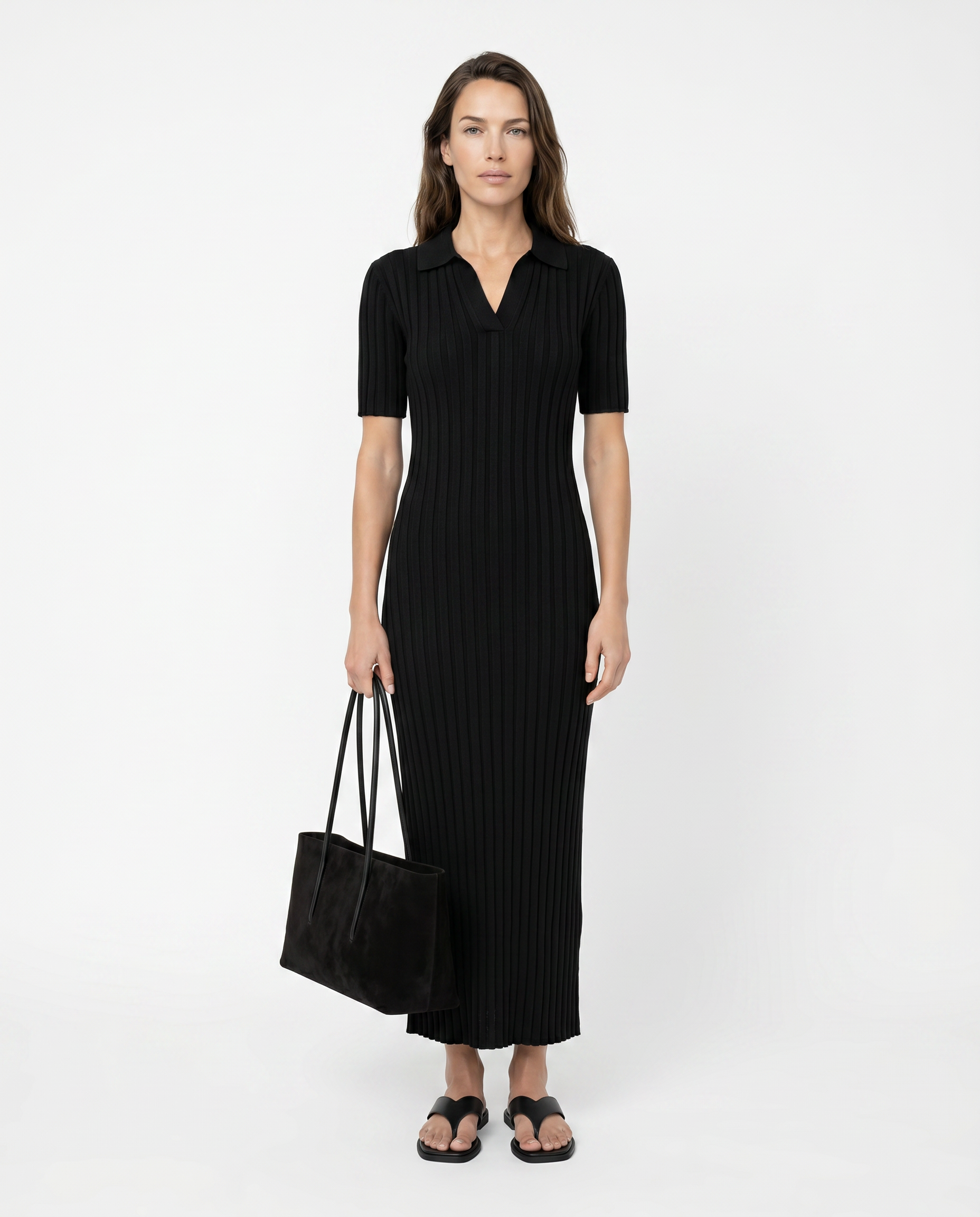 Woman wearing a black dress holding a black bag on a white background