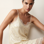 Woman wearing a white sequin dress against a plain background