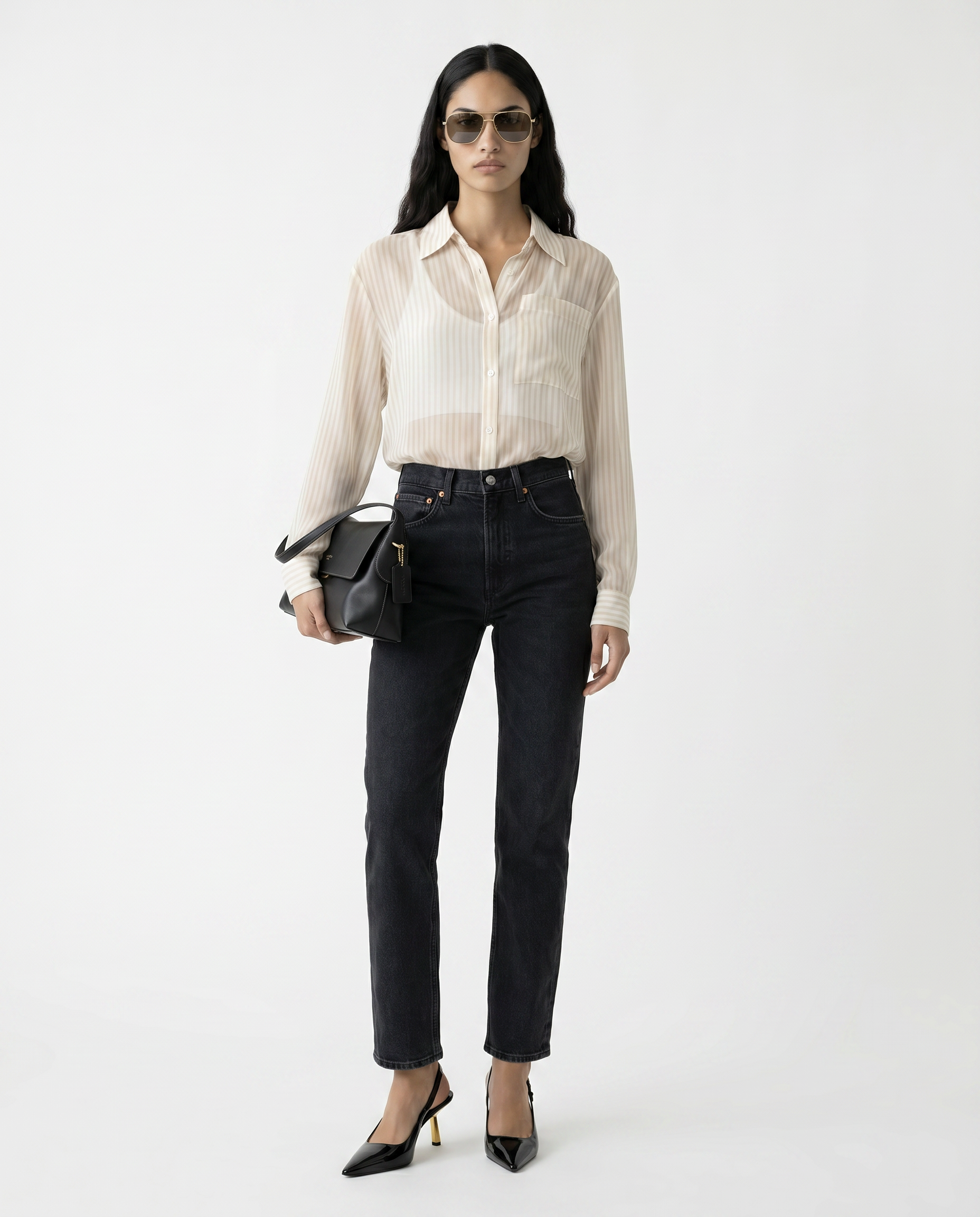 Woman wearing a beige blouse and black pants with sunglasses on a white background