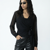 Woman wearing a black outfit with sunglasses on a white background