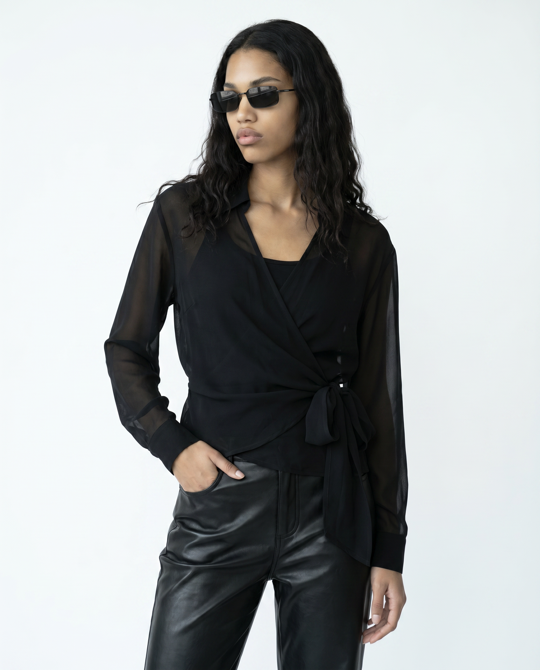 Woman wearing a black outfit with sunglasses on a white background